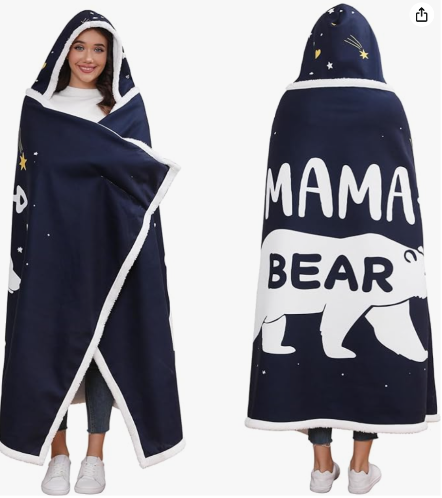 A woman wrapped up in a blue blanket with text printed on the blanket that says mama bear.
